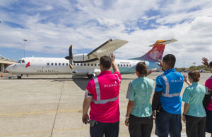 Island Air employees wave an outgoing flight